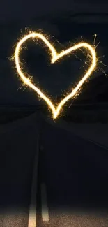 Heart-shaped sparkler glowing on a dark night road background.