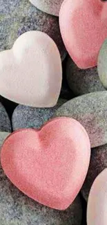 Heart-shaped pink stones on riverbed background.