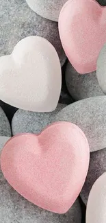 Pink and white heart-shaped stones on grey pebbles.