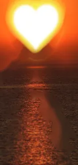 Heart-shaped sun setting over the ocean, casting a warm orange glow.