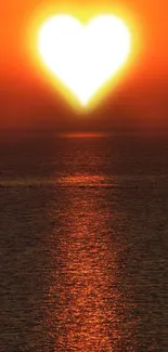 Heart-shaped sunset over ocean with glowing orange hue.