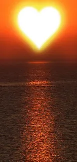 Sunset over ocean with heart-shaped sun reflecting light.