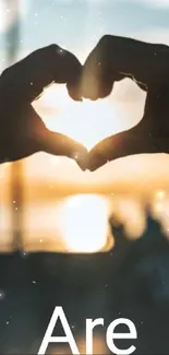 Heart hands silhouette with stunning sunset view.