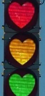 Heart-shaped traffic lights in red, yellow, and green against a blue sky.