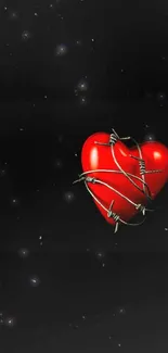 Red heart wrapped in barbed wire on black background.