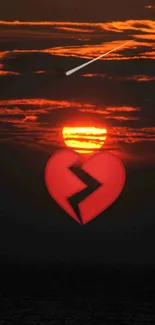 A broken heart over a fiery sunset sky.