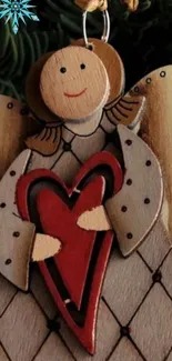 Wooden angel holding a red heart decoration.