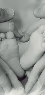 A monochrome image of baby feet cradled in heart-shaped hands, symbolizing family love.