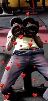 Person lifting dumbbells with floating red hearts in a gym setting wallpaper.