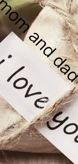 Heart-shaped rustic note saying 'I love you' with twine on a beige background.