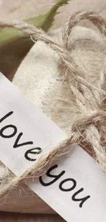 Heart wrapped in twine with 'I love you' note.