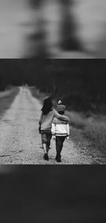 Black and white wallpaper of two kids walking on a path in nature.