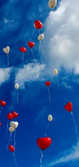 Heart-shaped balloons floating in a vibrant blue sky with white clouds.