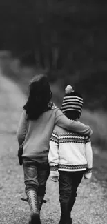 Black and white image of children walking on a wooded path.