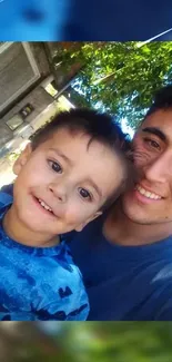 Father and son smiling together outdoors in a heartwarming family photo.