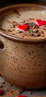 Rustic mug filled with hot chocolate and heart sprinkles.