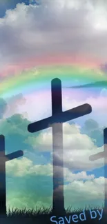 Three crosses under a vibrant rainbow and cloudy sky.