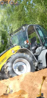 Heavy machinery on a dirt mound with green trees in the background.