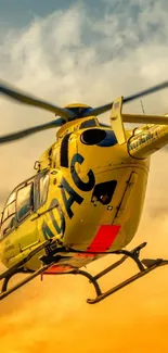 Helicopter flying in a vibrant sunset sky with orange and yellow hues.