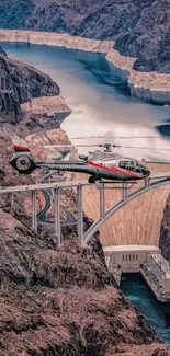 Helicopter flying over scenic canyon with winding river and towering bridge.