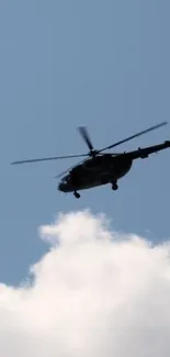 Helicopter flying against a bright blue sky with white clouds.