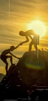 Silhouette of two people helping each other on a cliff at sunset.