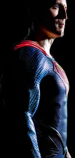 Dark silhouette of a superhero in a colorful suit against a black background.