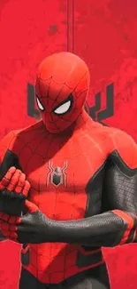 Red superhero with black accents in a powerful pose on wallpaper.