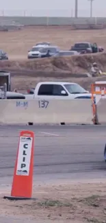 Dynamic car on race track with cones and barriers.