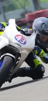 Motorcycle racer leans into turn on vibrant track.