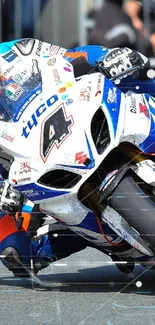 A motorcycle racer leans into a sharp turn during an exciting high-speed race.