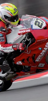 Professional motorcycle racer on a red bike at high speed.