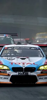 Race cars speeding on a wet race track with dark red accents.