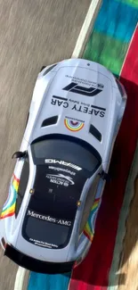 Top view of a Mercedes-AMG on a colorful racetrack curve.