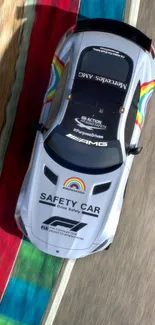 Overhead view of a safety car on a colorful race track.