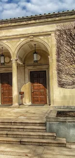 Historic building entrance with stone columns and wooden doors.