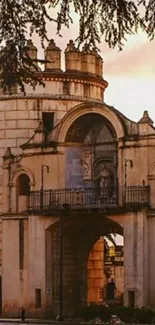 Historic archway set against a sunset sky, perfect for wallpaper.