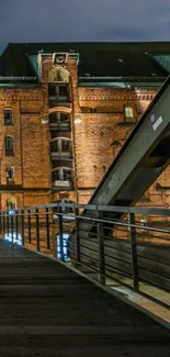 Historic brick building and bridge at night, warm lighting.