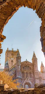 View of a historic cathedral through an ancient stone archway.