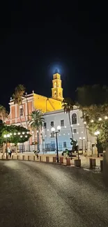 Beautiful night scene of a lit church with palm trees and streetlights.