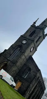 Mobile wallpaper showing a historic church tower under a cloudy sky.