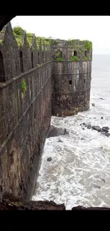 View of a coastal fort overlooking the ocean waves crashing against the stone walls.