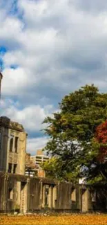 A-Bomb Dome with vibrant autumn colors and golden leaves under a cloudy sky.