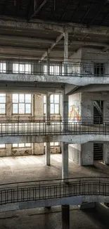 Interior view of an abandoned factory with layered balconies and large windows.