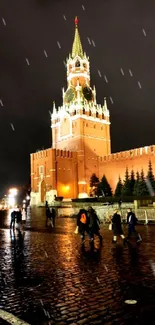 Night view of the Kremlin with illuminated towers and wet cobblestones.