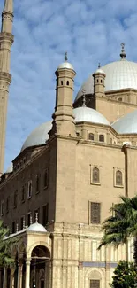 Historic mosque with domes and minarets against a blue sky.