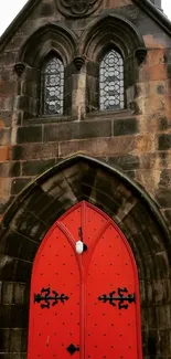 Red door set in a stone archway with Gothic design and vintage charm.