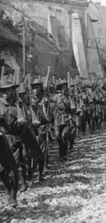 Black and white photo of marching soldiers in historical setting.