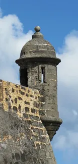 Historic stone tower with blue sky and clouds on mobile wallpaper.