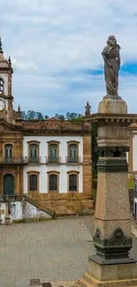 Historic town square with statue and clock tower.